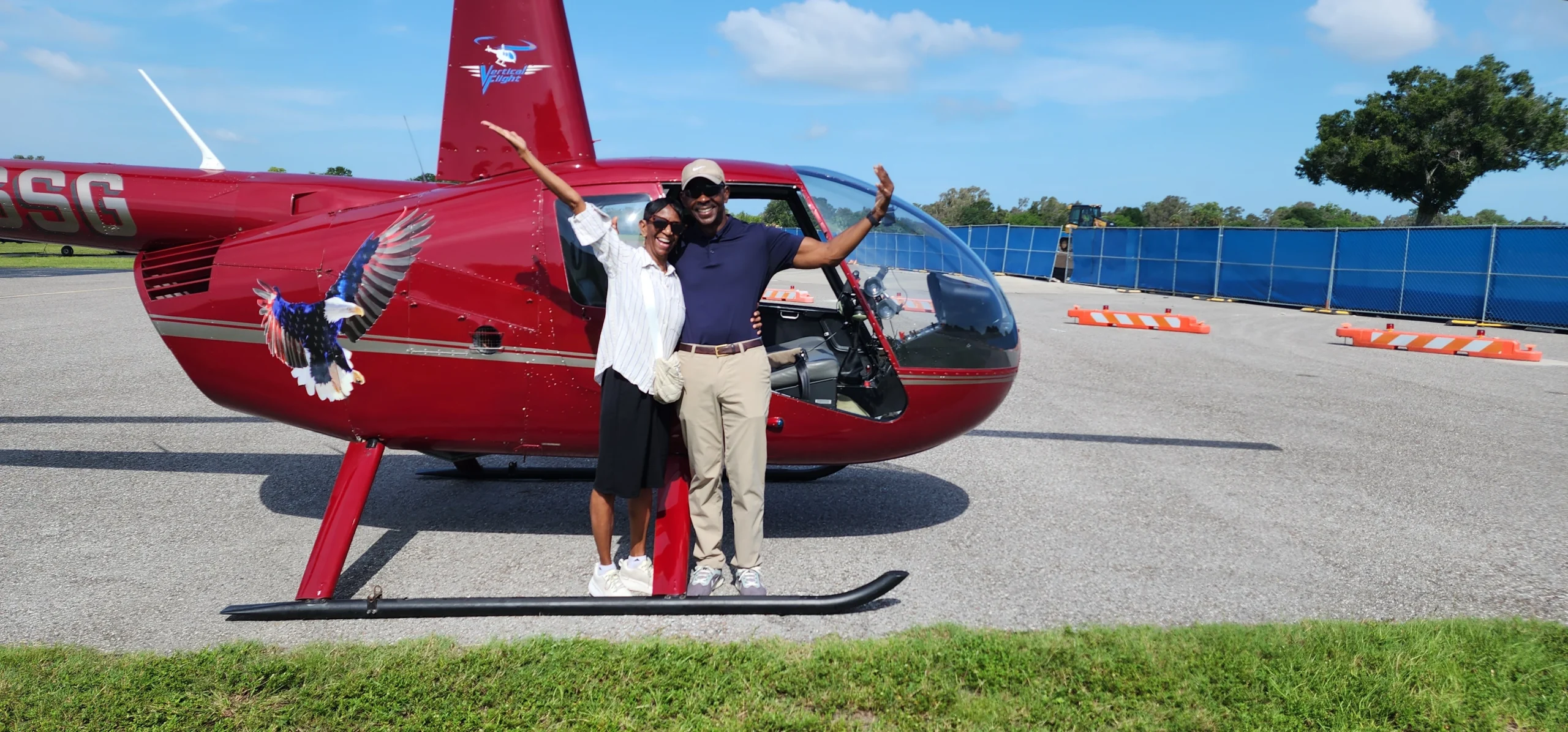 Vertical Flight guests posing beside a helicopter at Clearwater Airpark