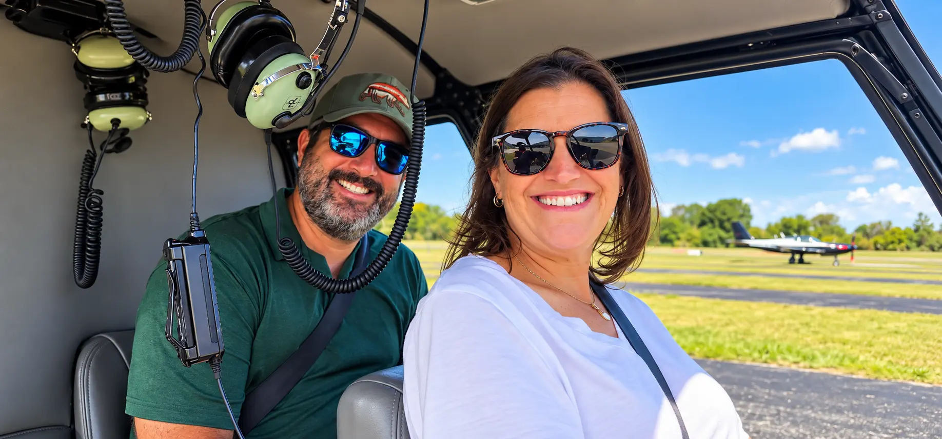 Guests smiling inside a Vertical Flight helicopter before their scenic flight