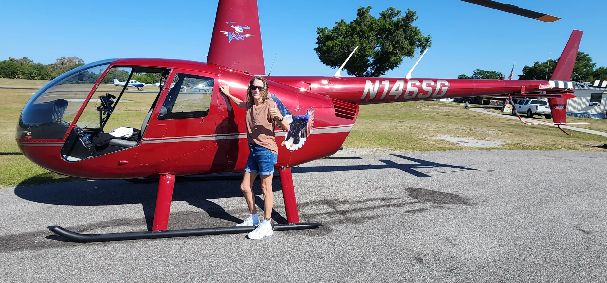 Vertical Flight's red Robinson R-44 Raven helicopter at Clearwater Airpark